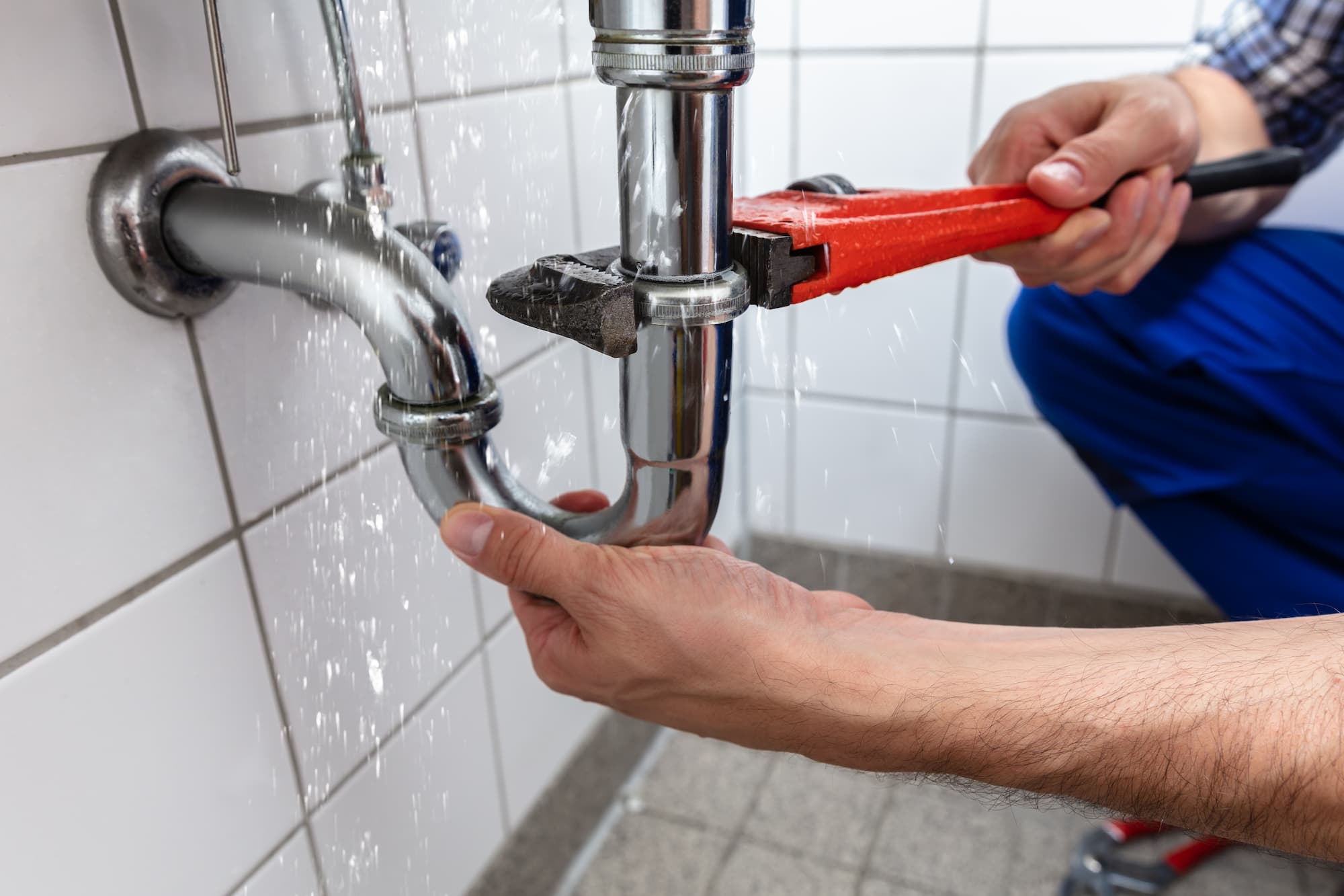 A plumber wourking with pipes under the sink